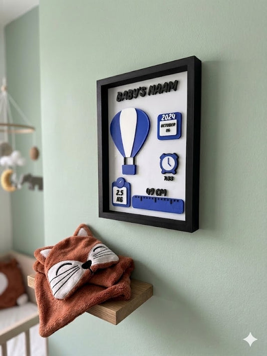 Gepersonaliseerd 3D geprint geboorteframe met naam, geboortedatum en een blauwe luchtballon aan een muur.